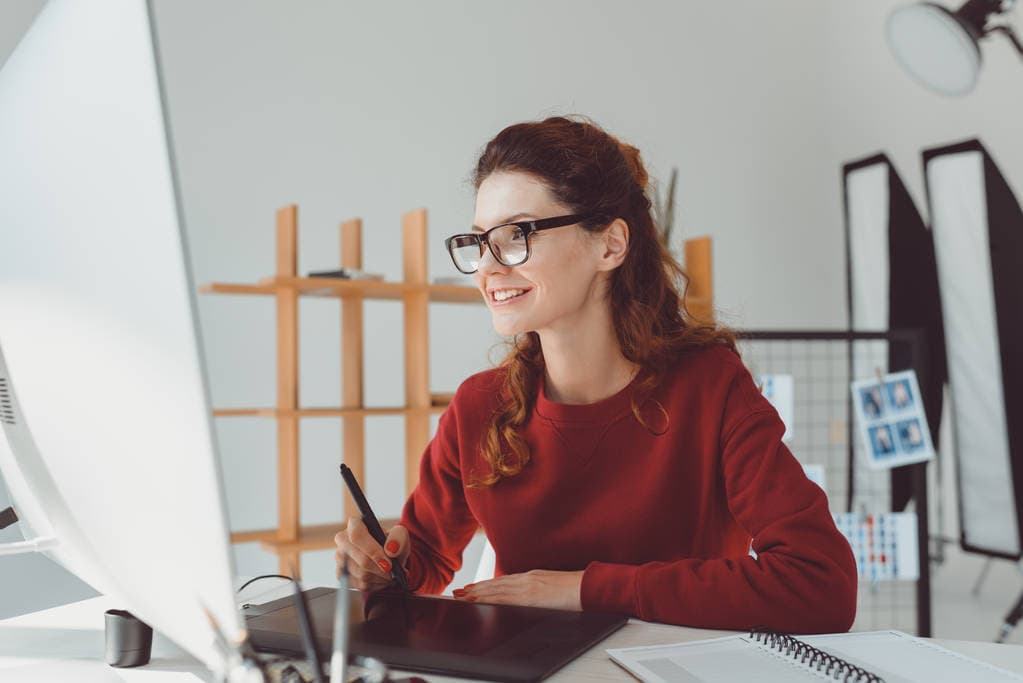 Graphic designer working on a drawing tablet at her desk